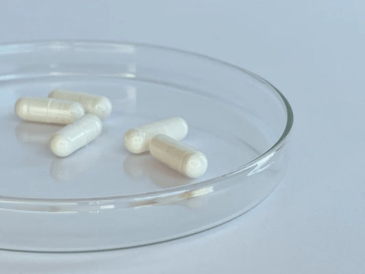 Close-up of off-white translucent Trans Resveratrol gelatin capsules in glass dish