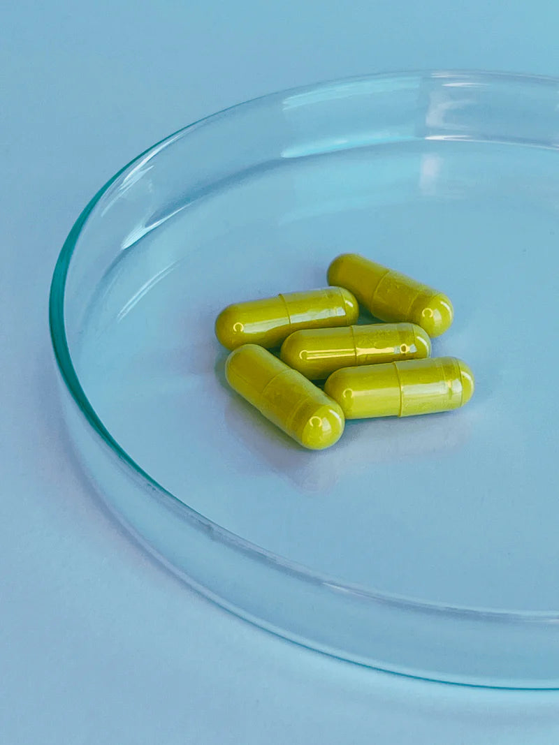 Yellow translucent L Cell Quercetin capsules in glass dish showing texture