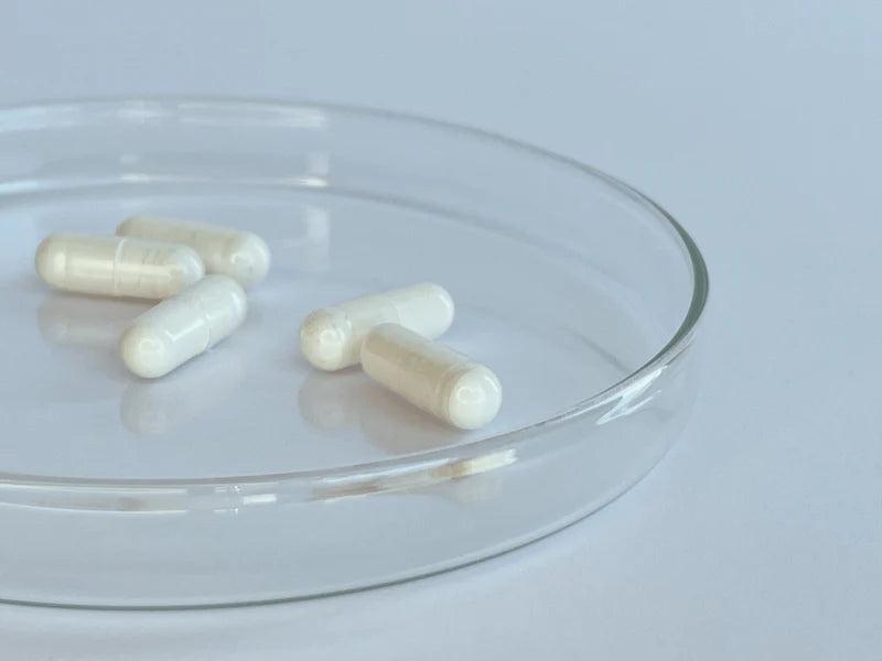 Close-up of off-white translucent Trans Resveratrol gelatin capsules in glass dish